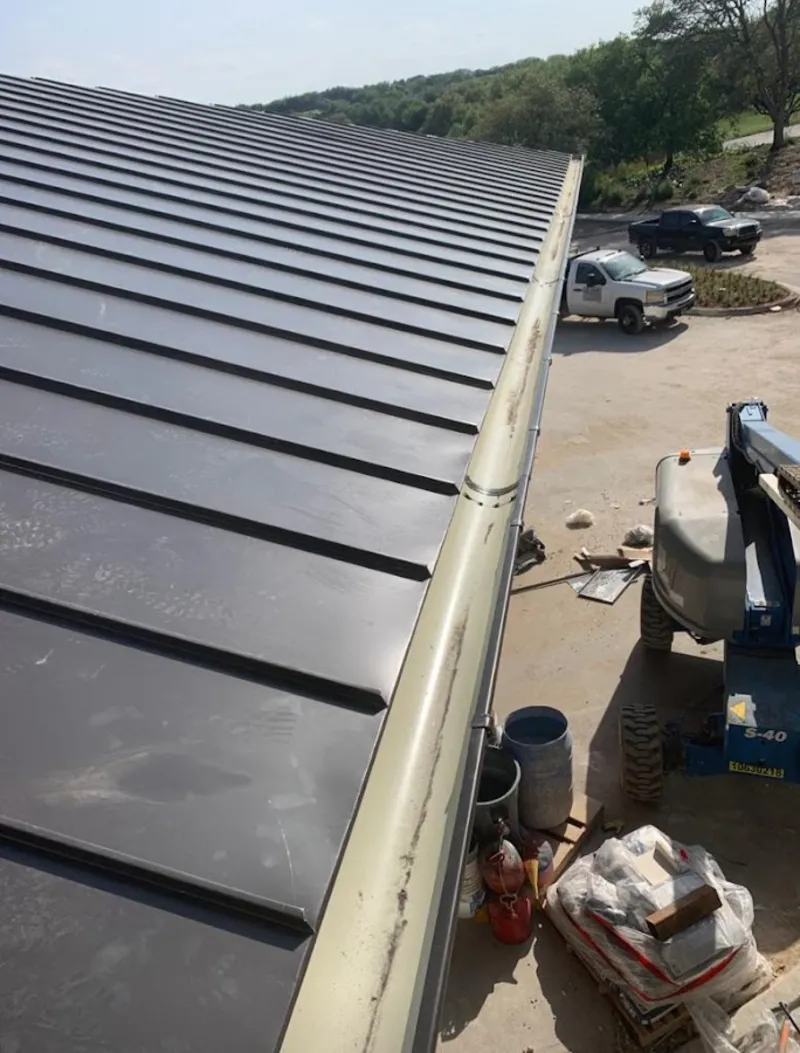 Standing seam panel and gutter detail on a metal roofing jobsite in Upton